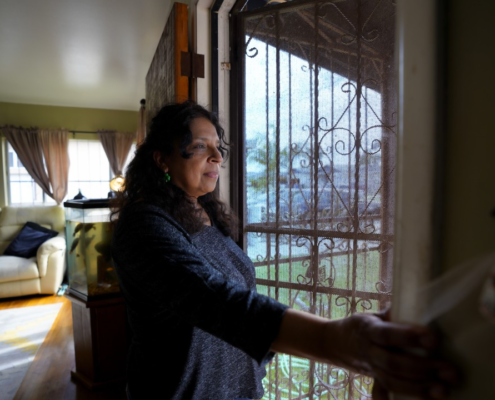 Esther Lopez settles in at home in Chula Vista after work at a nearby grocery store.(Nelvin C. Cepeda / The San Diego Union-Tribune)
